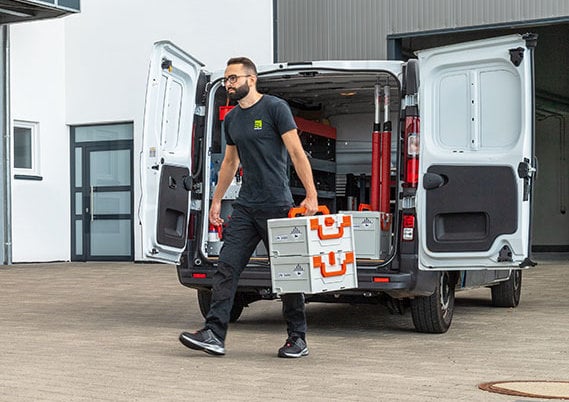 Man holding a battery system fire protection box from CEMO.